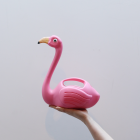 Hand die een flamingo gieter vast houdt